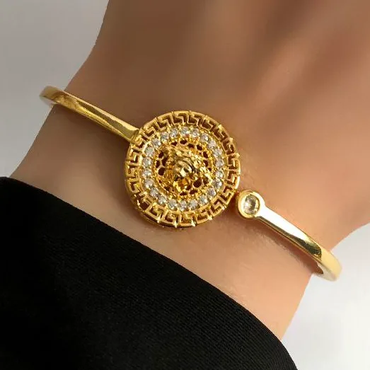 دستبند بنگل زنانه مدل ورساچه Versace نگین کاری شده رنگ طلایی جنس برنجی با آبکاری نقره ضد حساسیت رنگ ثابت کد zsm (پس کرای